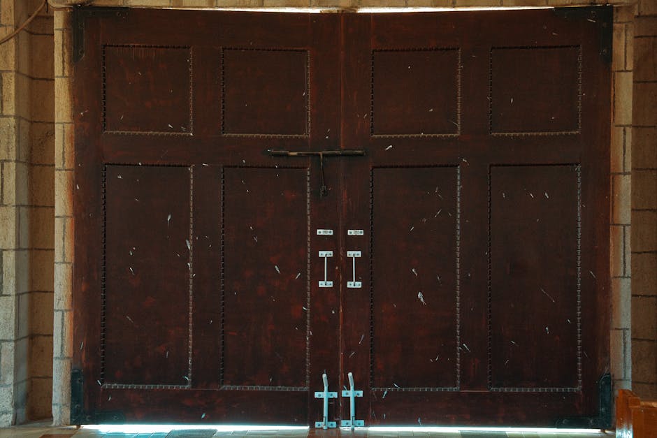 A set of rustic wooden double doors featuring metal latches and a textured surface, ideal for architectural themes.